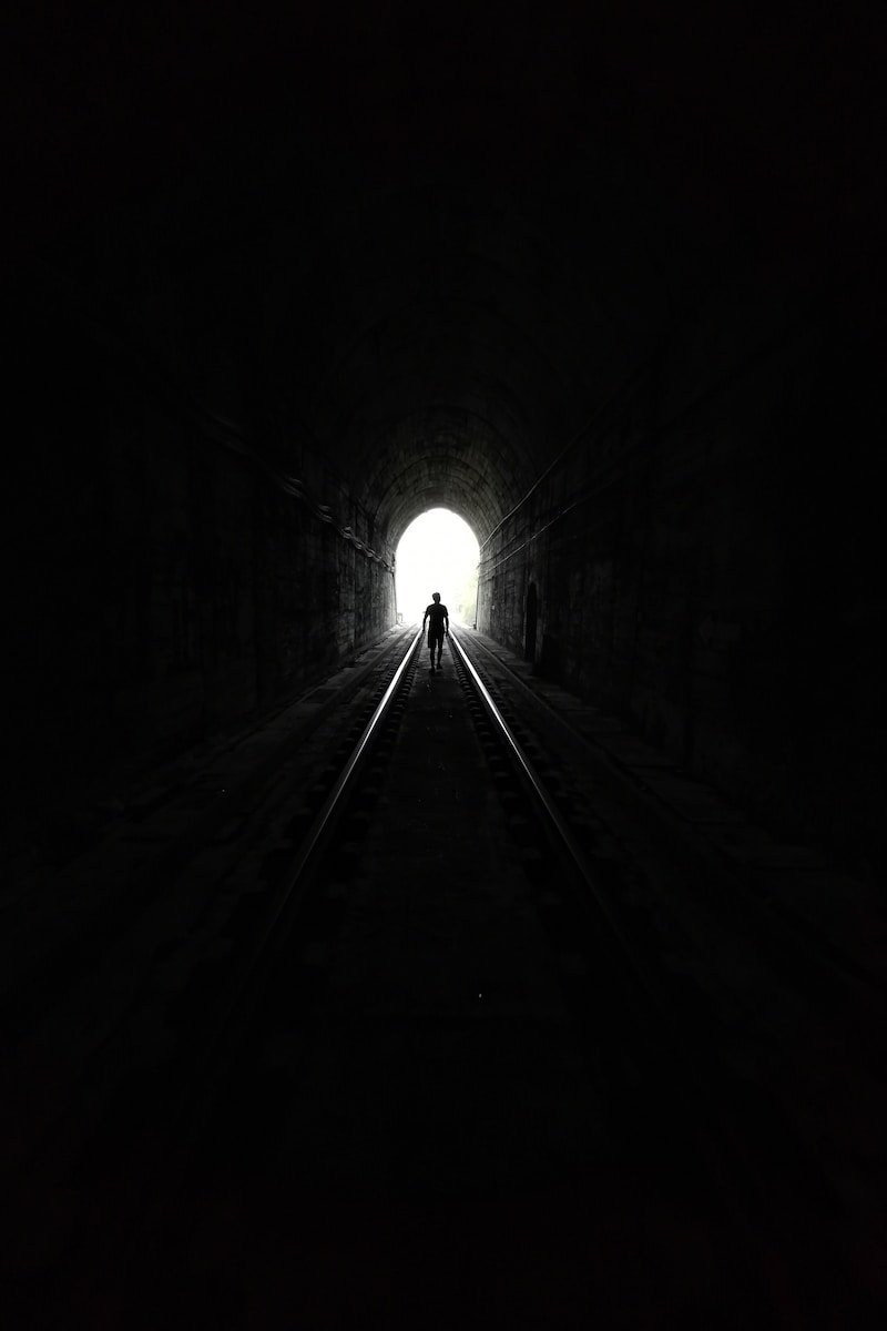 grayscale photo of tunnel with light